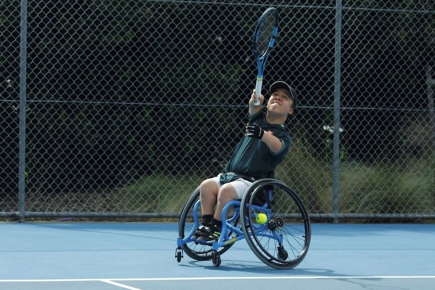 A young man with dwarfism playing wheelchair tennis