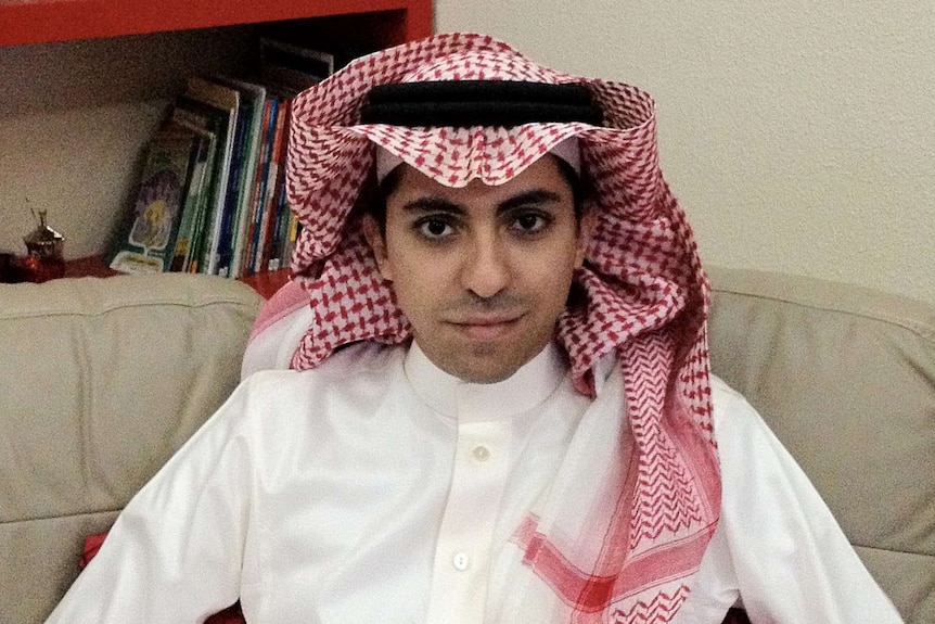 an image of a saudi man sitting on a couch looking at the camera in white clothes and a keffiyeh