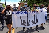 Camden County Metro Police Chief Joe Wysocki raises a fist while marching with Camden residents and activists.