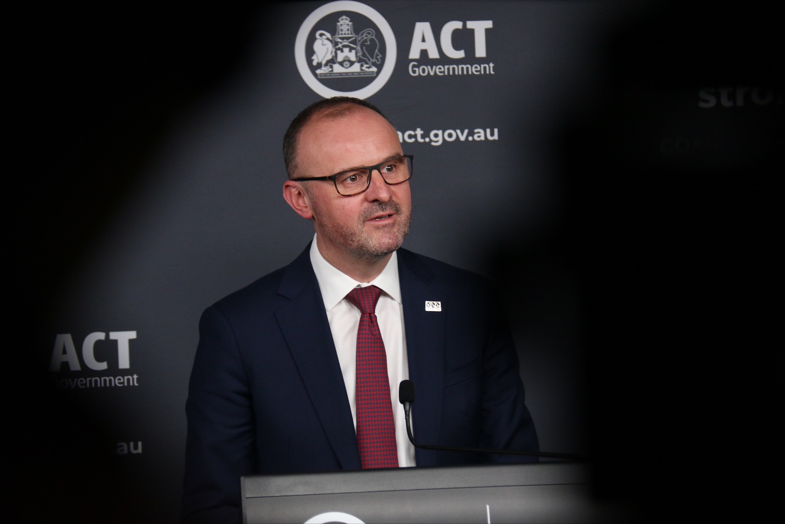 Andrew Barr speaks at a press conference with media watching on.