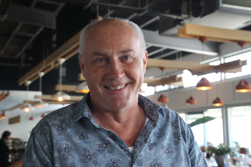 Odyssea part owner Fabio Hupfer stands, smiling in his restaurant