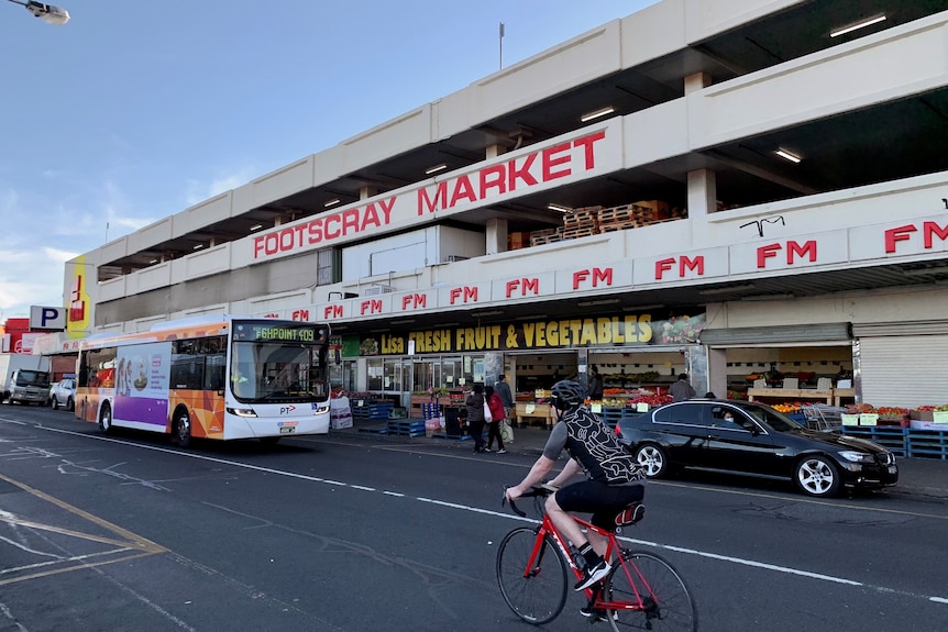 A cyclist rides past Footscray Market.