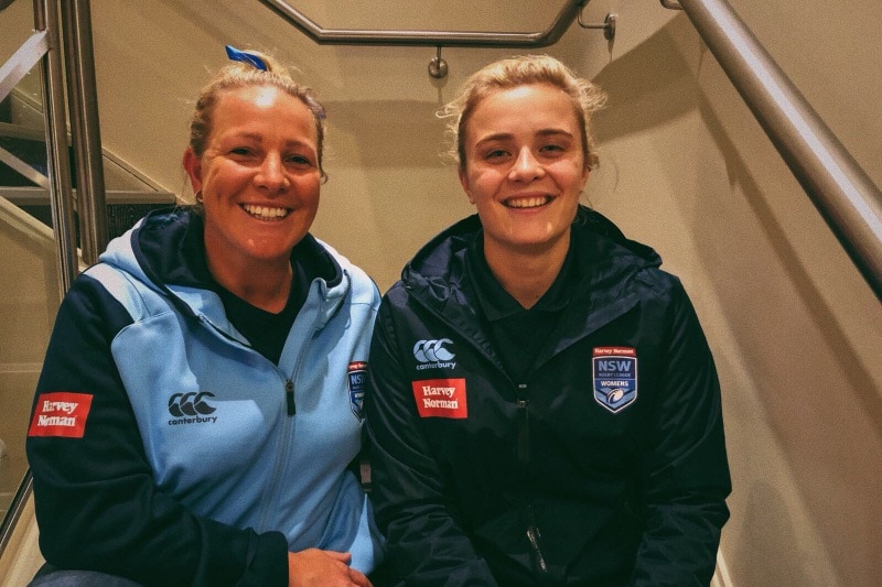 Two women sitting on a stairwell smiling