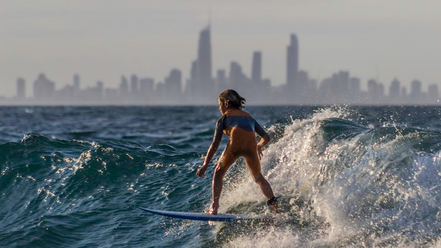 A young surfer catches a wave on the Gold Coast