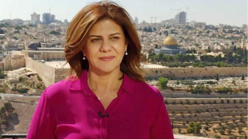 A female journalist stands in Jerusalem and looks into the distance