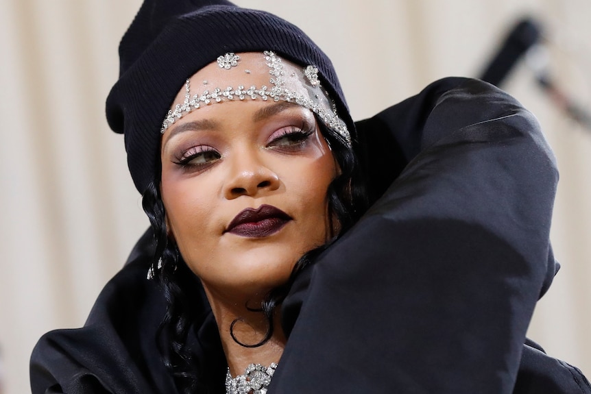 Rihanna wearing a black outfit and silver crown