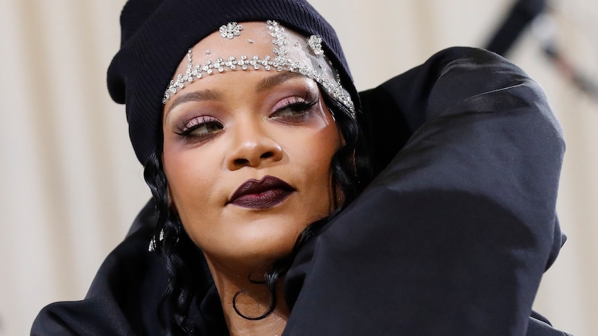 Rihanna wearing a black outfit and silver crown