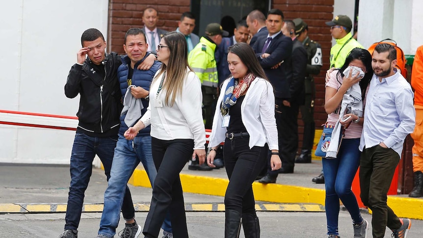 Family members of victims of a bombing cry outside the entrance to the General Santander police academy.