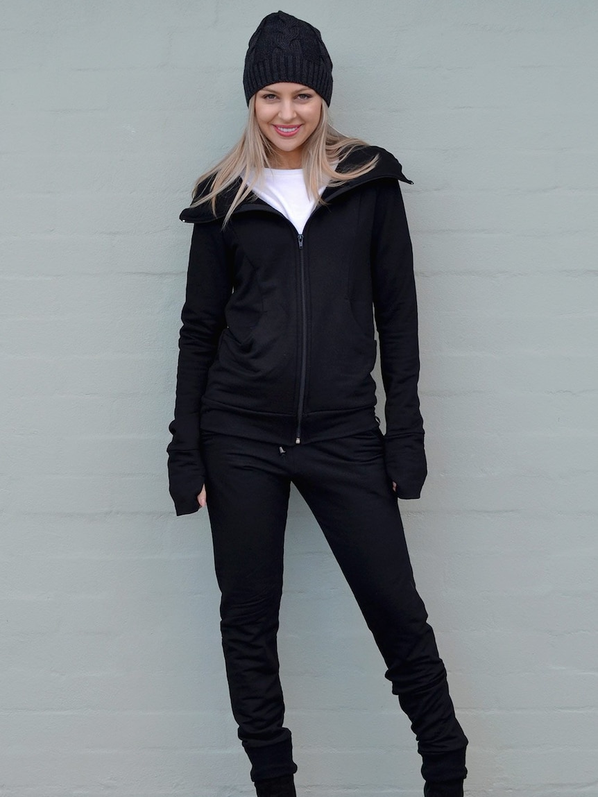 a woman models a merino beanie, jacket and fleece pants