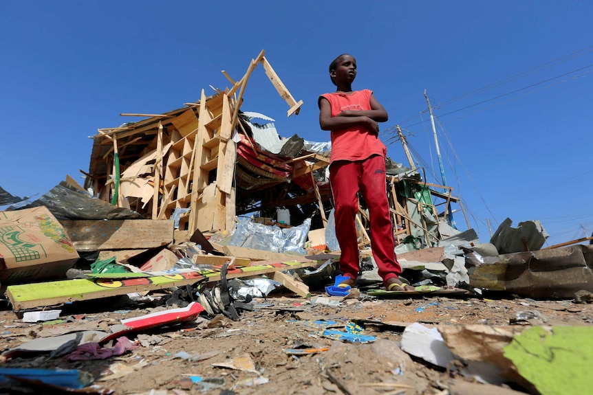 A boy outside the wreckage of his shop in Mogadishu after a bomb blast.