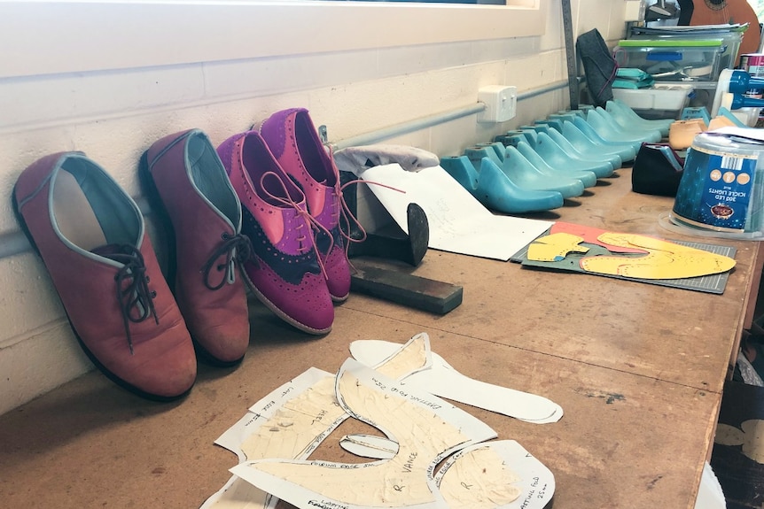 Handmade shoes lined up on a wall