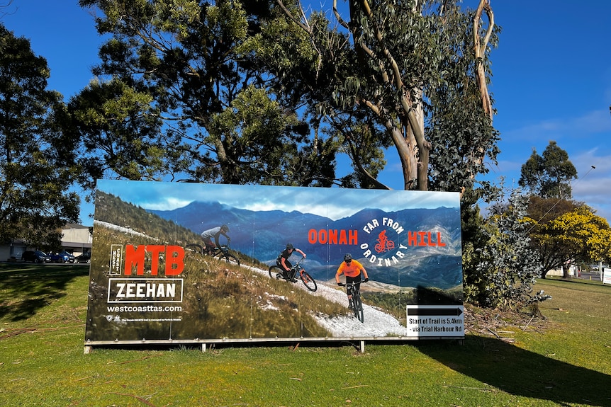 A large colourful sign on intersection in Zeehan touts the mtb experience of Oonah Hill