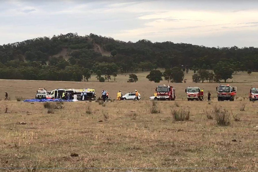 Fire engine, ambulance etc. at crash scene in field.