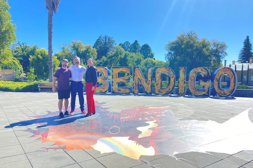 a picture of an art installation and bendigo sign and three people posing 