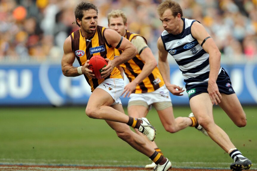 Hawthorn's Chance Bateman is chased by Geelong's Darren Milburn during an AFL game at the MCG in 2011.