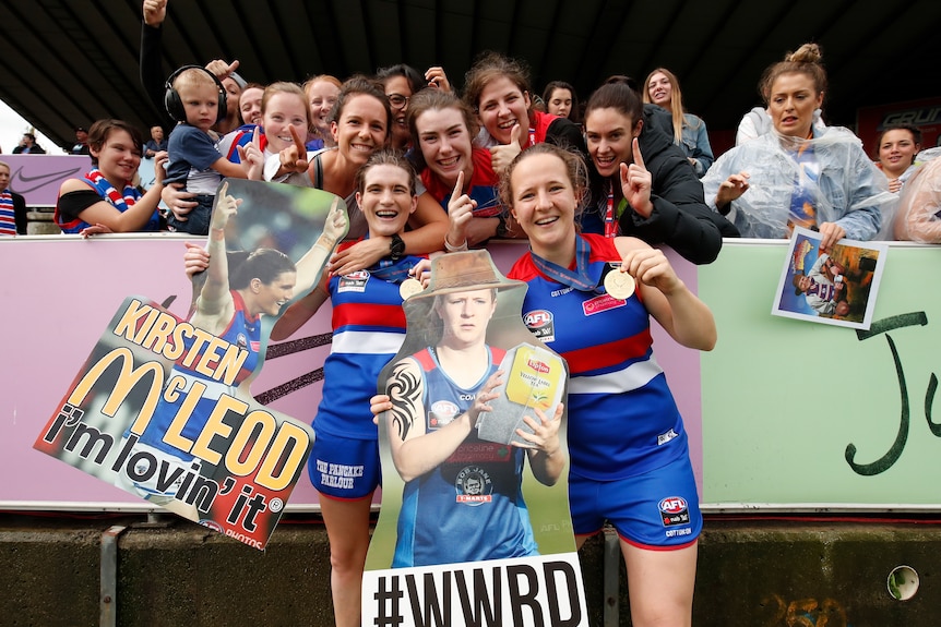 Kirsten McLeod and Hayley Wildes pose for photos with fans after the Bulldogs' grand final win