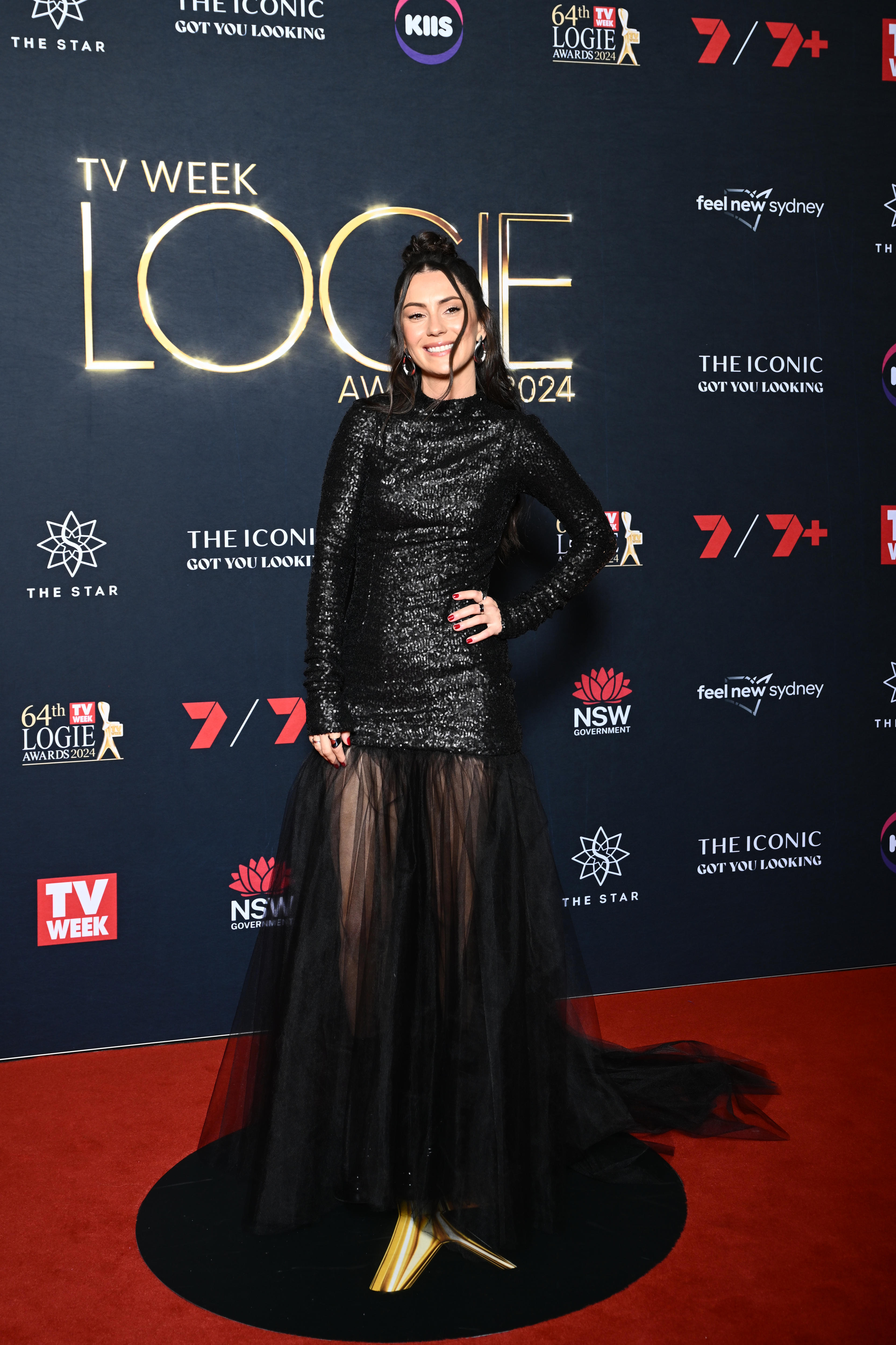 Amy Shark wears a shimmering black long-sleeved dress