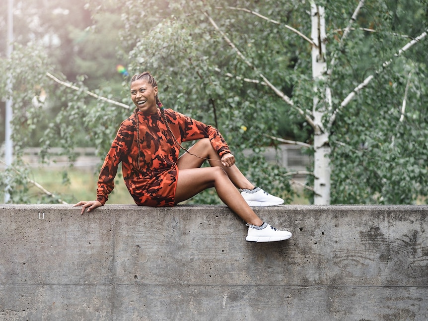 a woman sits on a park ledge 