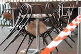Chairs leaning up against a table at an outdoor cafe.