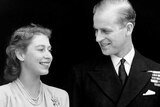 A black and white photo of Princess Elizabeth and Philip Mountbatten smiling as they stand side by side.