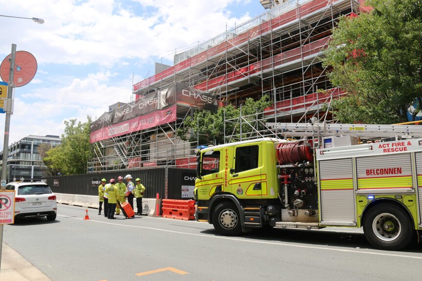 A fire truck and emergency services outside the construction site.