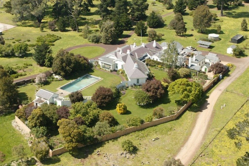 A large sprawling white home situated among green pastures