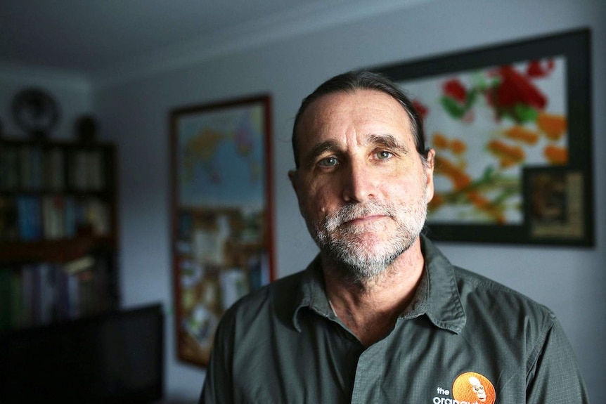 Conservationist Leif Cocks stands looking at the camera in a room.