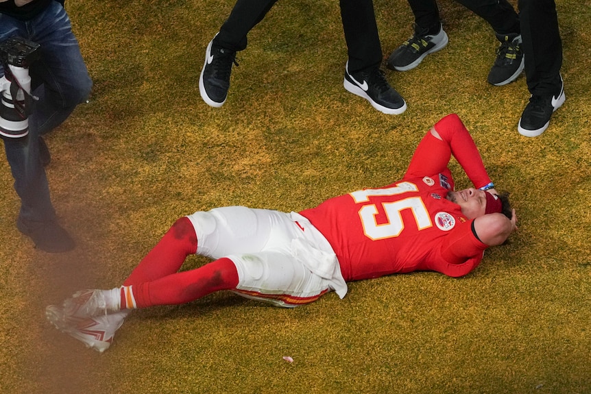 Patrick Mahomes lies on the field after winning Super Bowl LVIII.