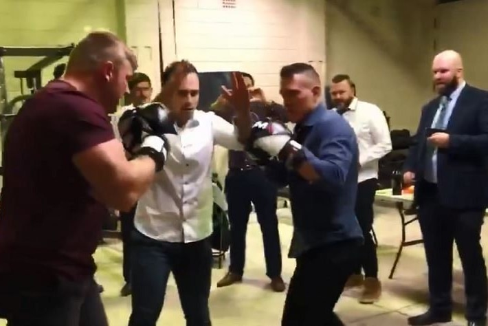 Men at one of the "Lads Society" fight nights sparring with other members watching on.
