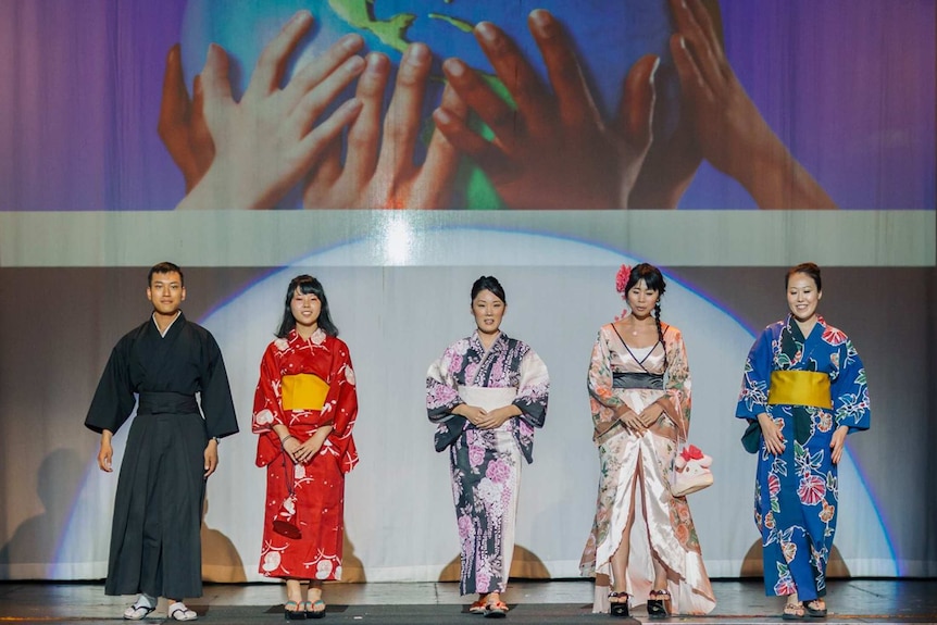 Five people dressed in Japanese traditional fashion.