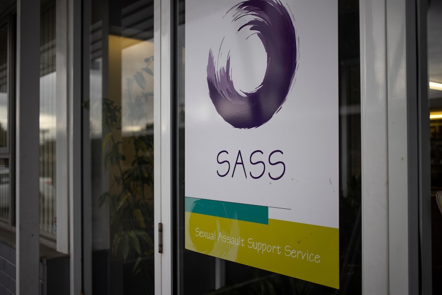 A door with a decal of a circular logo and the acronym "SASS" below it