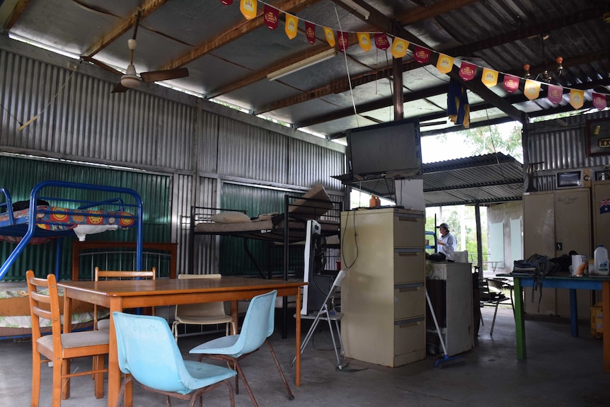 Corrugated iron shed hold simple furniture bunk beds, tv, cabinets, tables chairs.