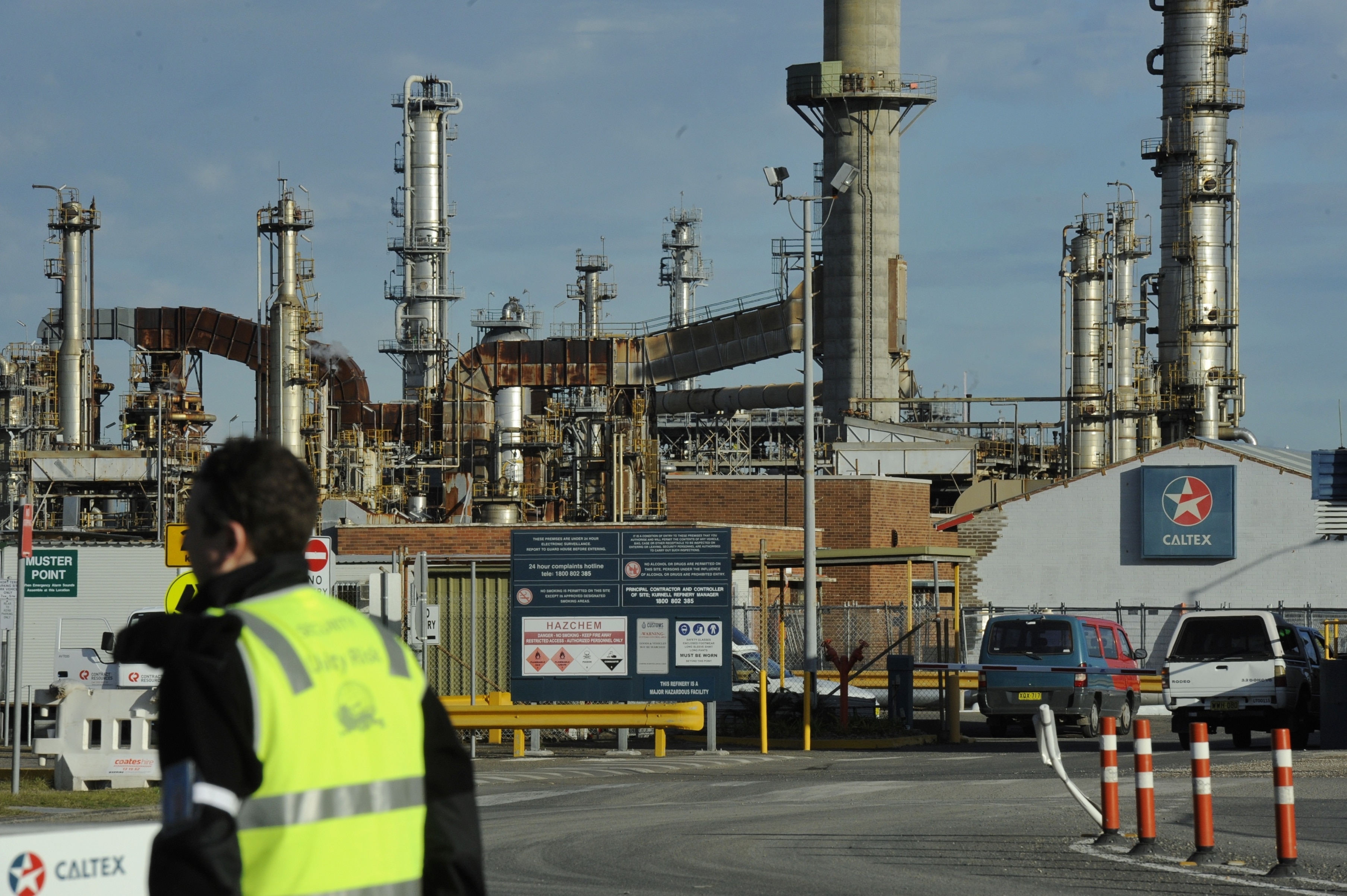Worker stands outside Caltex oil refinery in Kurnell