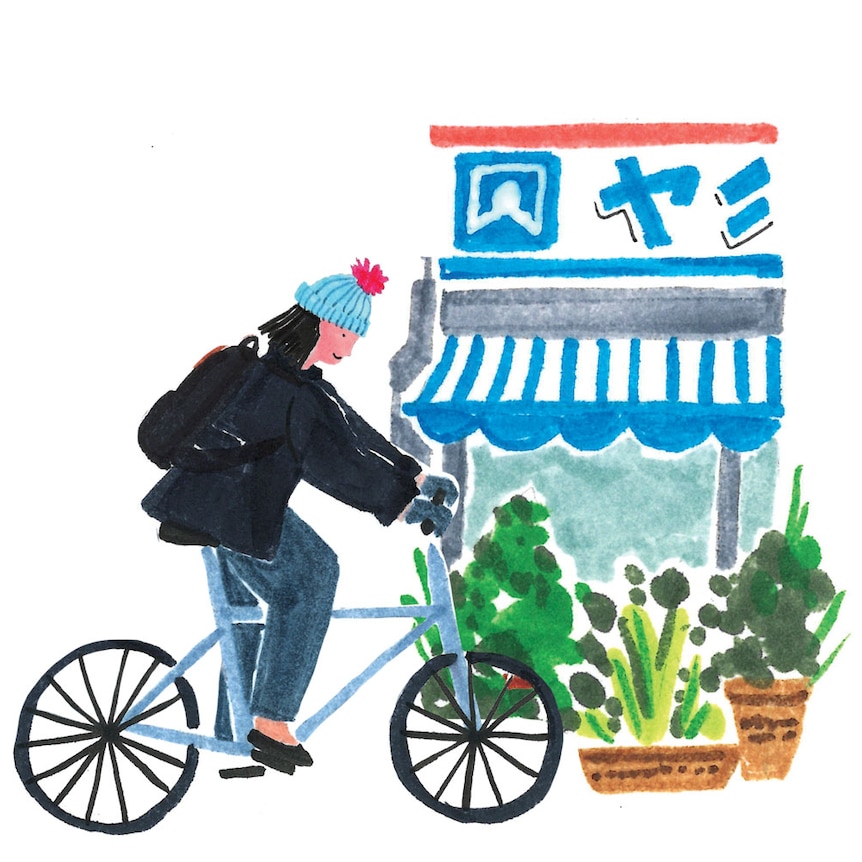 Grace riding bike past a shop