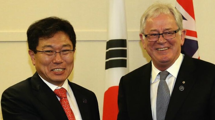 Andrew Robb and his South Korean counterpart Yoon Sang-jick shake hands on the free trade agreement.