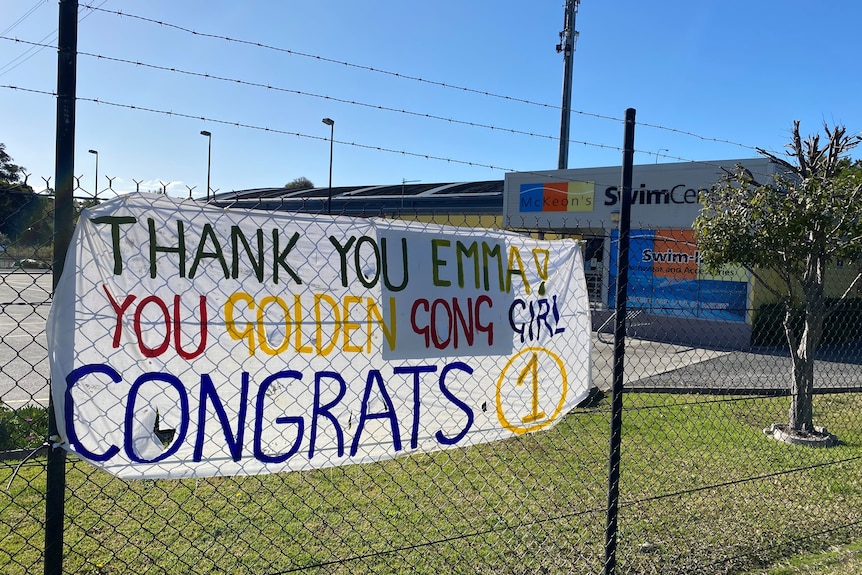 A banner congratulating Emma McKeon decorates a fence at the McKeon Swim School in Wollongong.