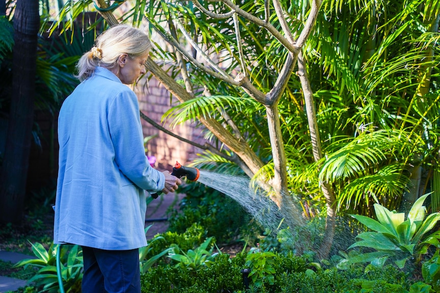 Linda Molloy watering her garden.