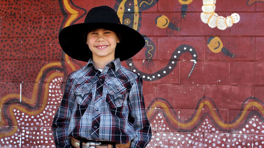 Young boy dressed in western wear.