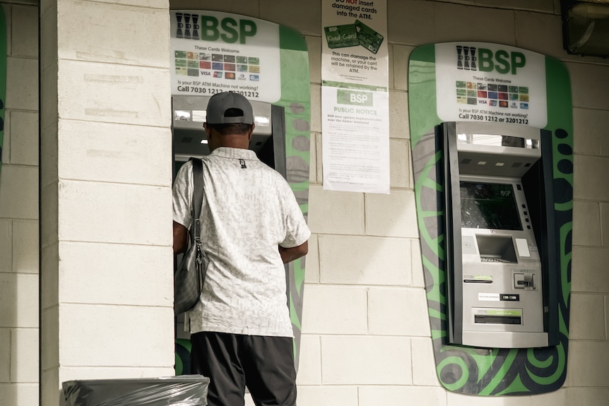 A man uses a Bank South Pacific ATM in PNG,