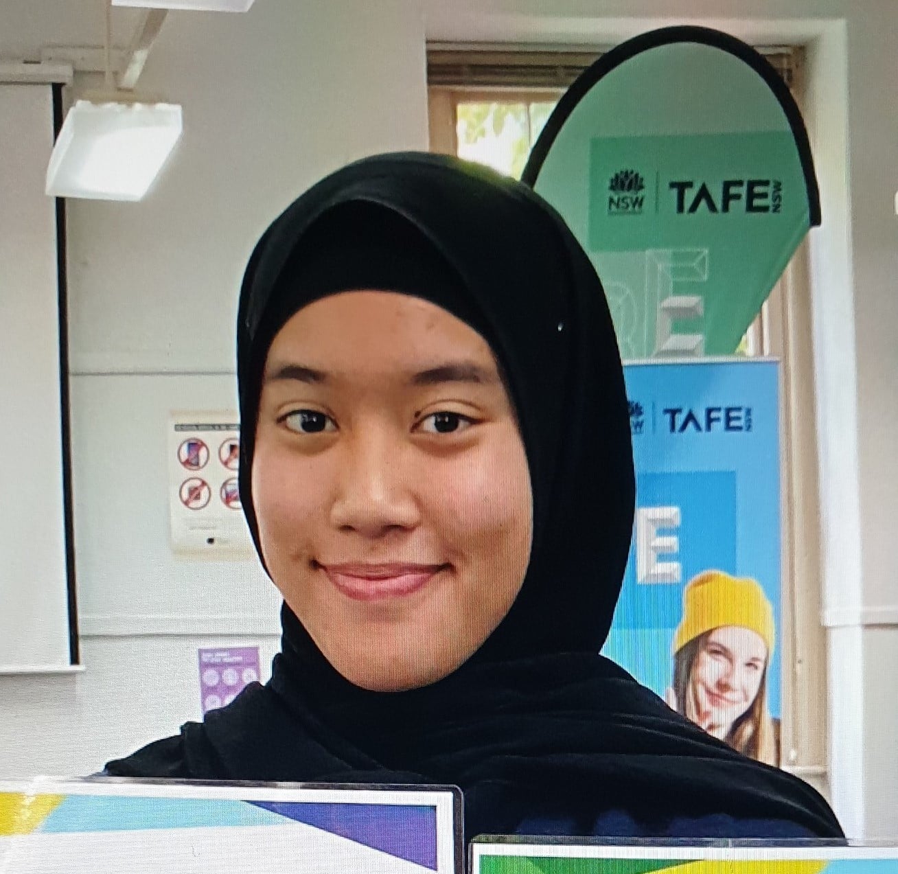 A young woman wearing a black head covering.