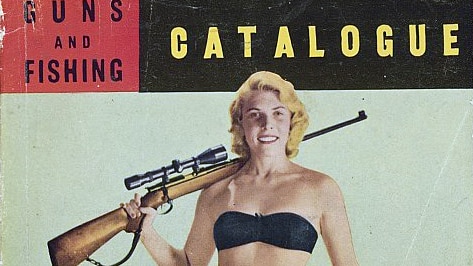 A woman wearing a bikini holds a rifle.