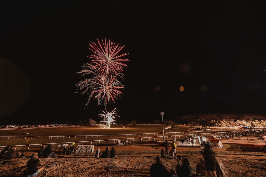 Fireworks in a night sky over an outback race track