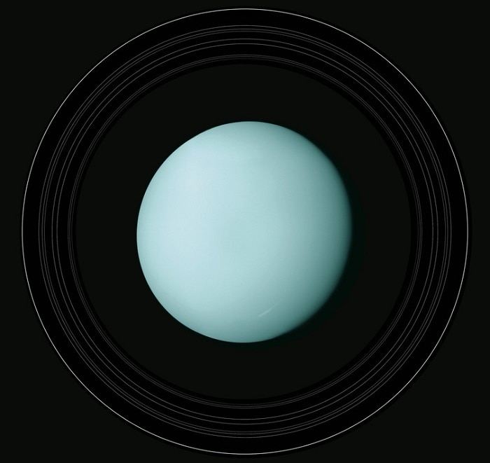 A view of Uranus, light blue in colour and with thin rings around it