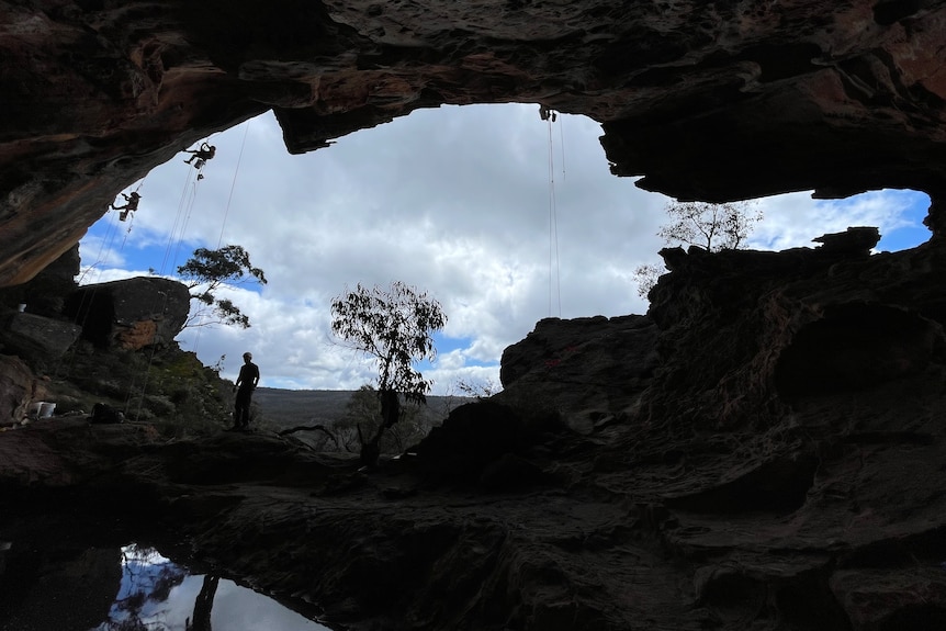 The internal of Millennium Cave in the shadow highlighting the daylight outside with a silhouette of a man.