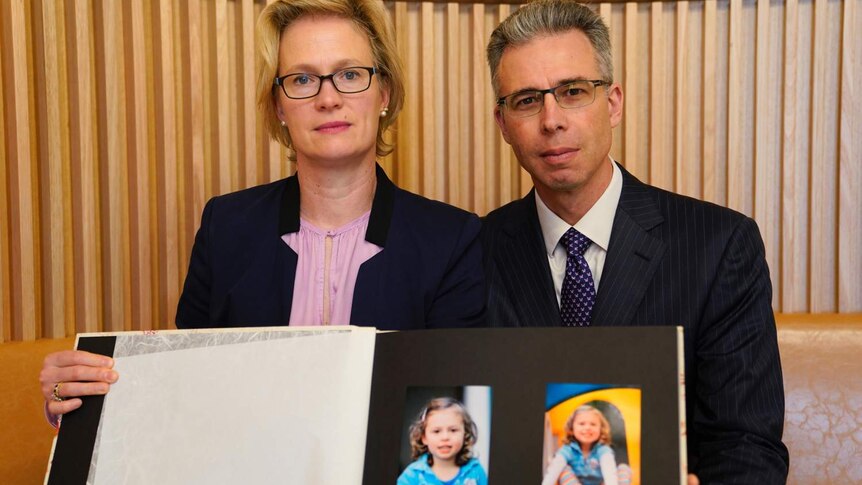 Mr and Mrs Gibson with photos of their young daughter who died.