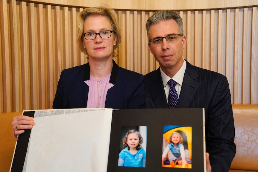 Mr and Mrs Gibson with photos of their young daughter who died.