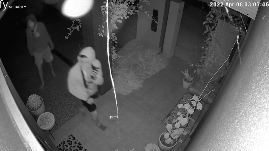 CCTV of two young men looking around a home