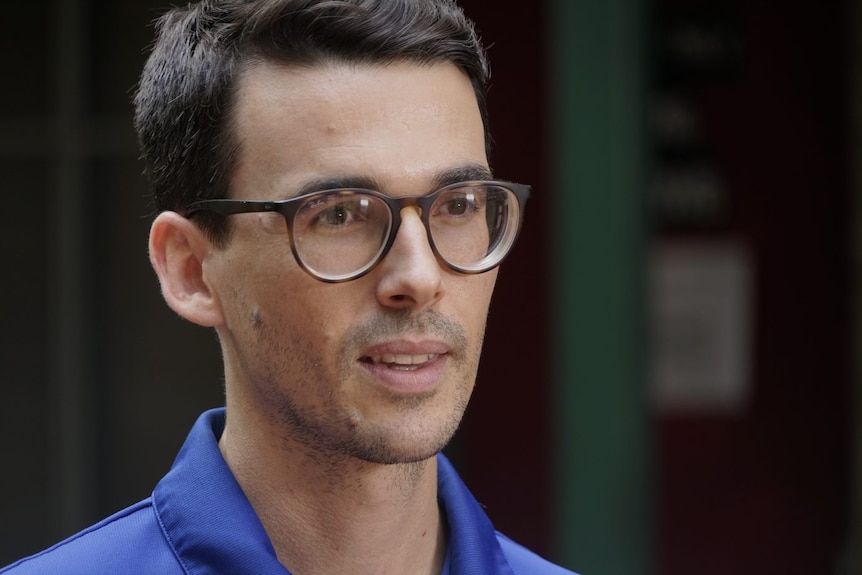 A man with black hair wears glasses at a press conference in Darwin at Danila Dilba Health Service. 