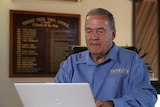 Ian Bodill looks at a laptop screen while sitting in his office.