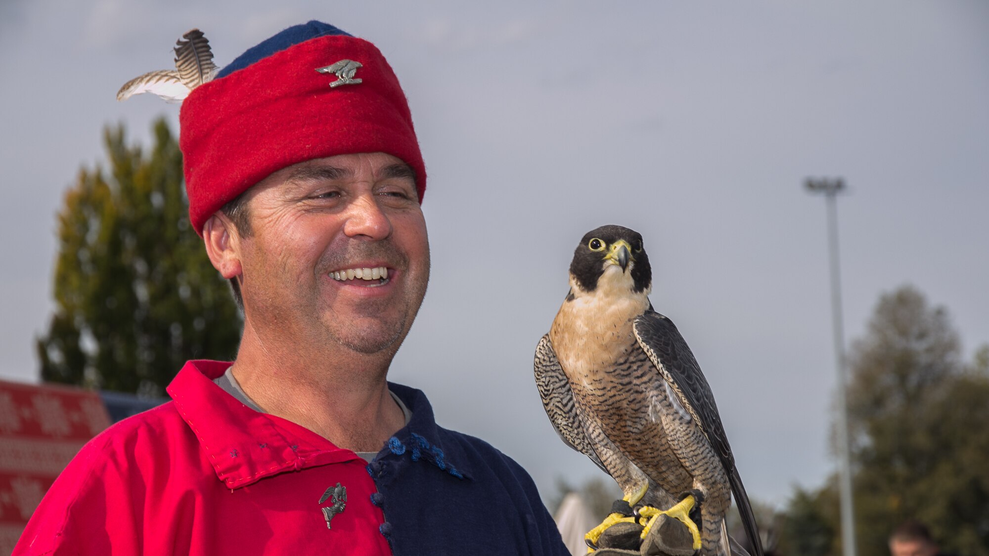 A man in medieval dress with a falcon on his gloved hand